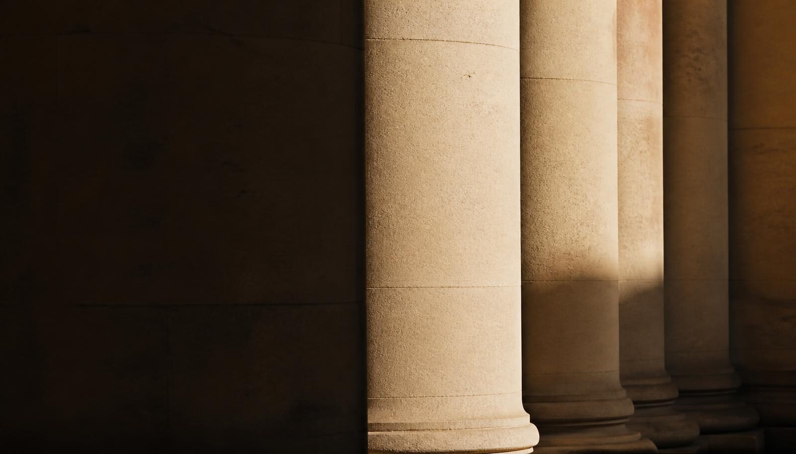 Pale limestone columns in low, warm side light