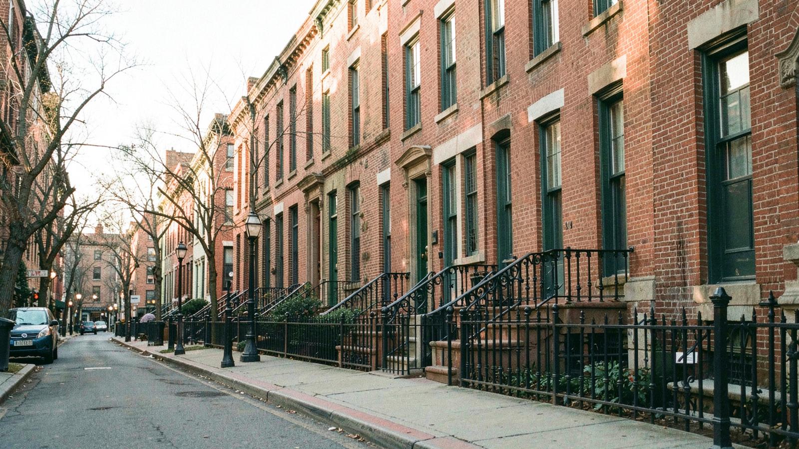 A Dupont Circle rowhouse street in Washington, D.C., brick facades and iron railings in late afternoon light